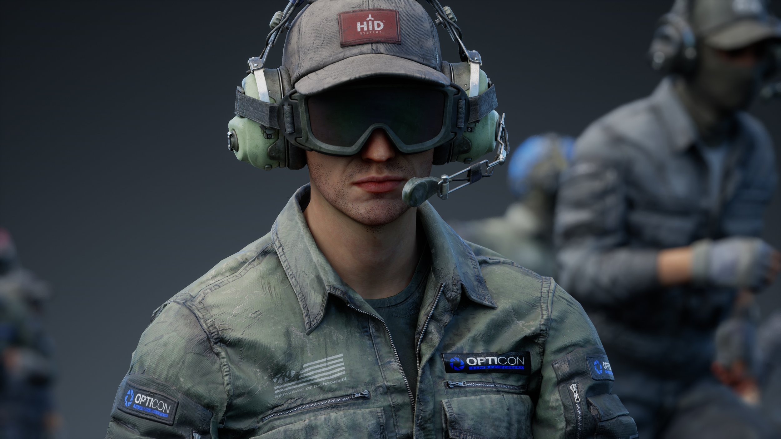 the image is a closeup shot of a soldier, likely from a video game like call of duty, wearing tactical gear. he is wearing a camouflage jacket with opticon and hid systems patches visible.  the soldier has on a headset with a boom microphone, protective goggles, and a baseball cap.  his expression is serious. the background is blurry but shows other soldiers in similar gear, indicating a team or squad dynamic in a military or combat setting. the overall mood is intense and focused.
