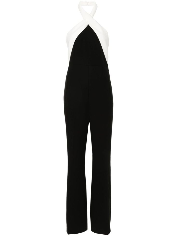 a black and white halter neck jumpsuit. the top of the jumpsuit is white and the bottom is black. the jumpsuit is a formal piece of clothing that would be perfect for a night out.