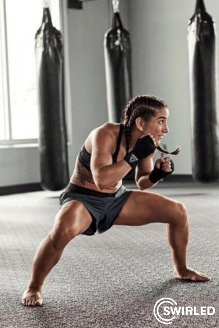 a female athlete in boxing gloves is training in the gym. she is practicing punches and kicks in front of a punching bag. she is wearing sportswear and appears focused on her technique. the image captures the energy and strength of the fighter.