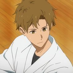 the image shows a young anime boy with brown hair and eyes wearing a white robe. he is looking down with a serious expression on his face. the background is a wooden floor.