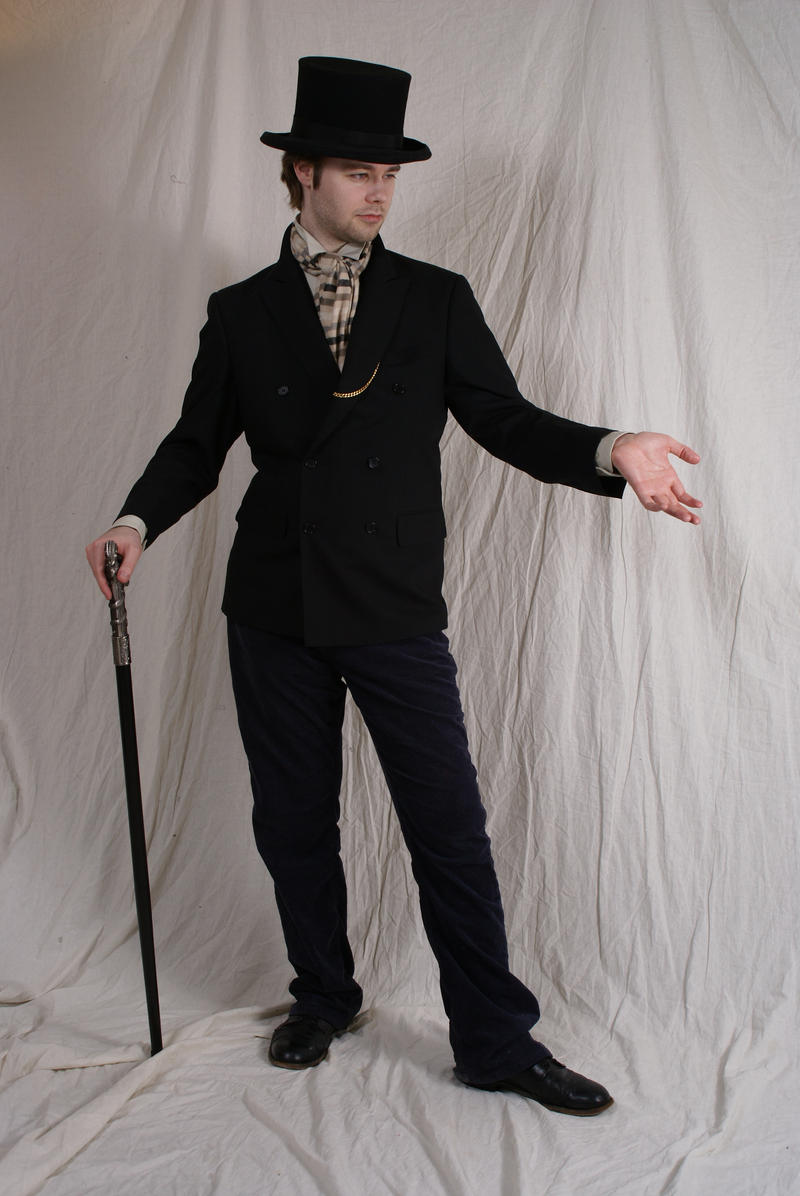 a fullbody studio shot of a man dressed in a vintagestyle suit, including a top hat, jacket, trousers, and shoes. he is holding a cane and is standing against a white background, gesturing with his hand.