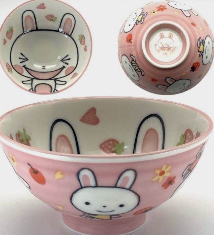 the image shows a pink ceramic bowl decorated with bunny rabbits, strawberries, hearts, and flowers. the bowl has a wide rim and a slightly raised base. the inside of the bowl is white and features more bunny rabbit designs. there are three views of the bowl: a topdown view, a bottom view, and a side view.
