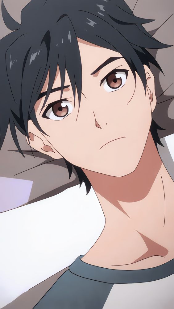 this closeup image showcases a young man from an anime series. he is resting against a light gray pillow, possibly on his bed, with his gaze directed slightly upwards. the lighting is soft and emphasizes his delicate features, particularly his large brown eyes. his relaxed posture and neutral expression create a sense of calm contemplation.