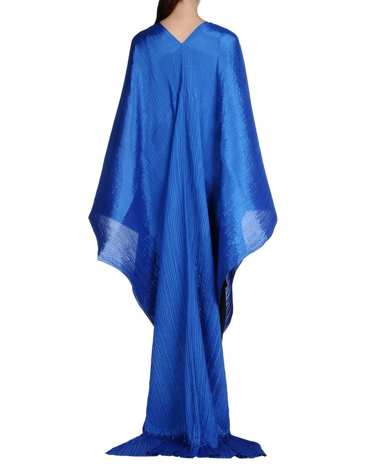 an image of a person wearing a long blue dress with a vneck, standing against a white background.