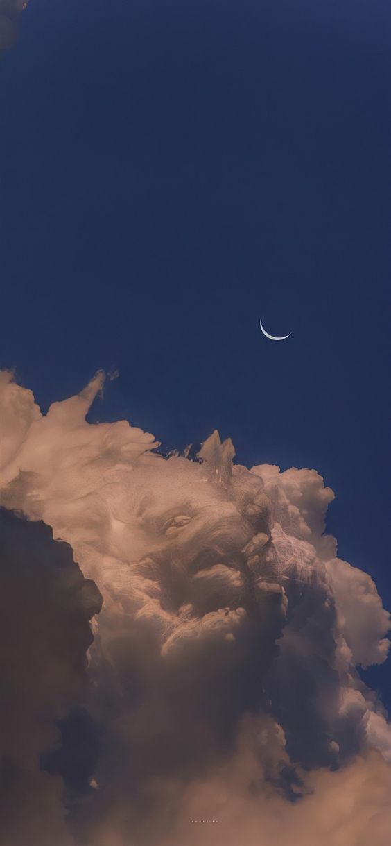the image is a landscape of the sky at dusk. the sky is a deep blue color, and the moon is a thin crescent in the upper right corner. there is a large, fluffy cloud in the lower left corner of the image that is a light orange color. the overall feeling of the image is peaceful and serene.