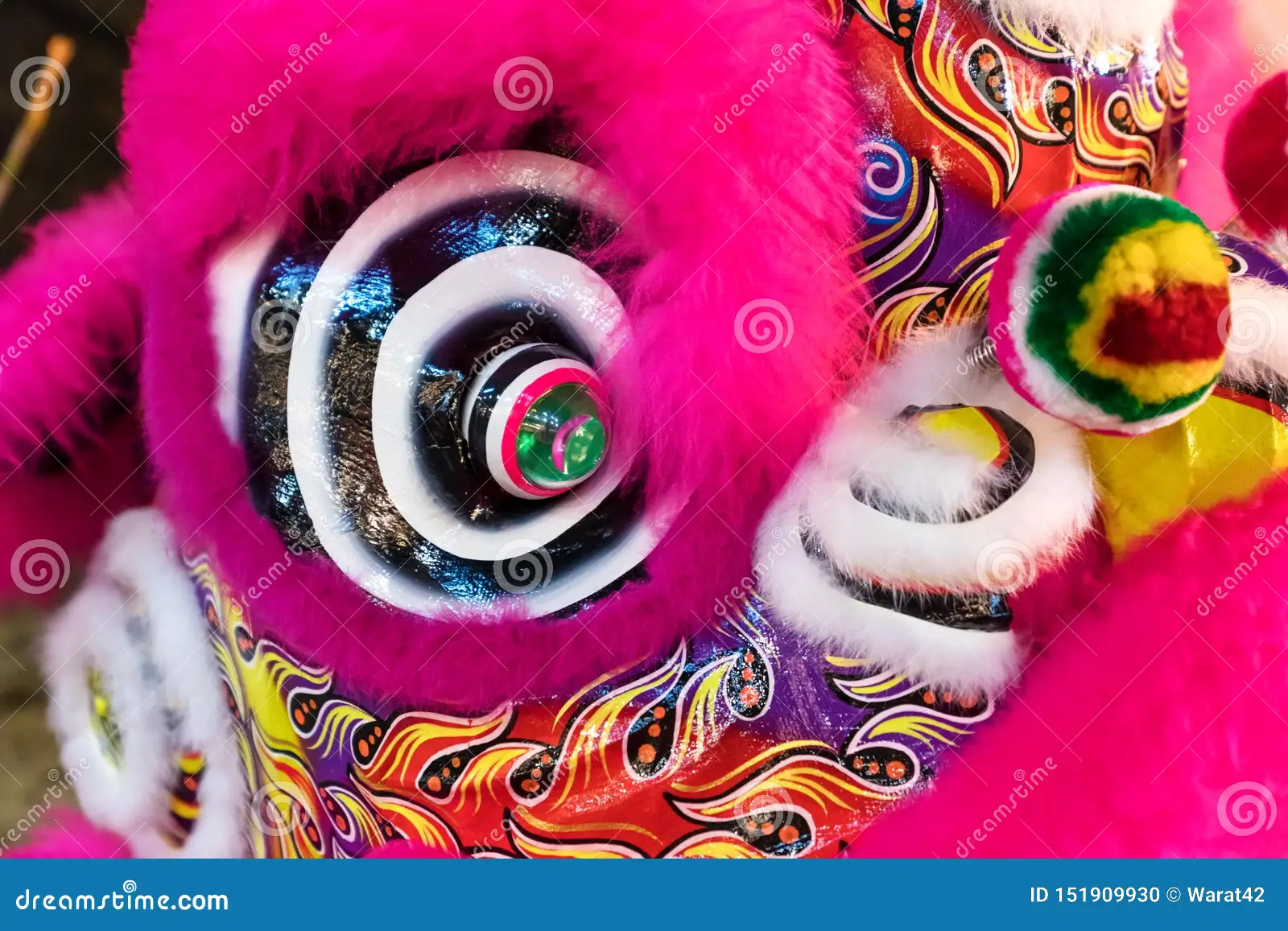 close up image of the head of a pink, brightly colored, traditional chinese lion dance costume.