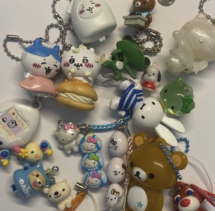the image shows a collection of various keychains. there are several hello kitty keychains, a rilakkuma bear, chiikawa, and other anime or cartoonthemed charms. they are laid out against a white surface.