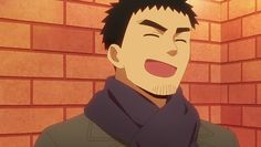 the image shows a man with short black hair and stubble. he is wearing a gray jacket and a dark blue scarf. he is standing in front of a red brick wall and is smiling broadly, with his eyes closed. the lighting is warm and inviting, suggesting that the scene is taking place either indoors or during the day.content: man, smile, laughter, portraitpeople: manenvironment: indoors, brick walllighting: warm, invitingperspective: eye levelkw: happy, joyful, content, warm, approachable