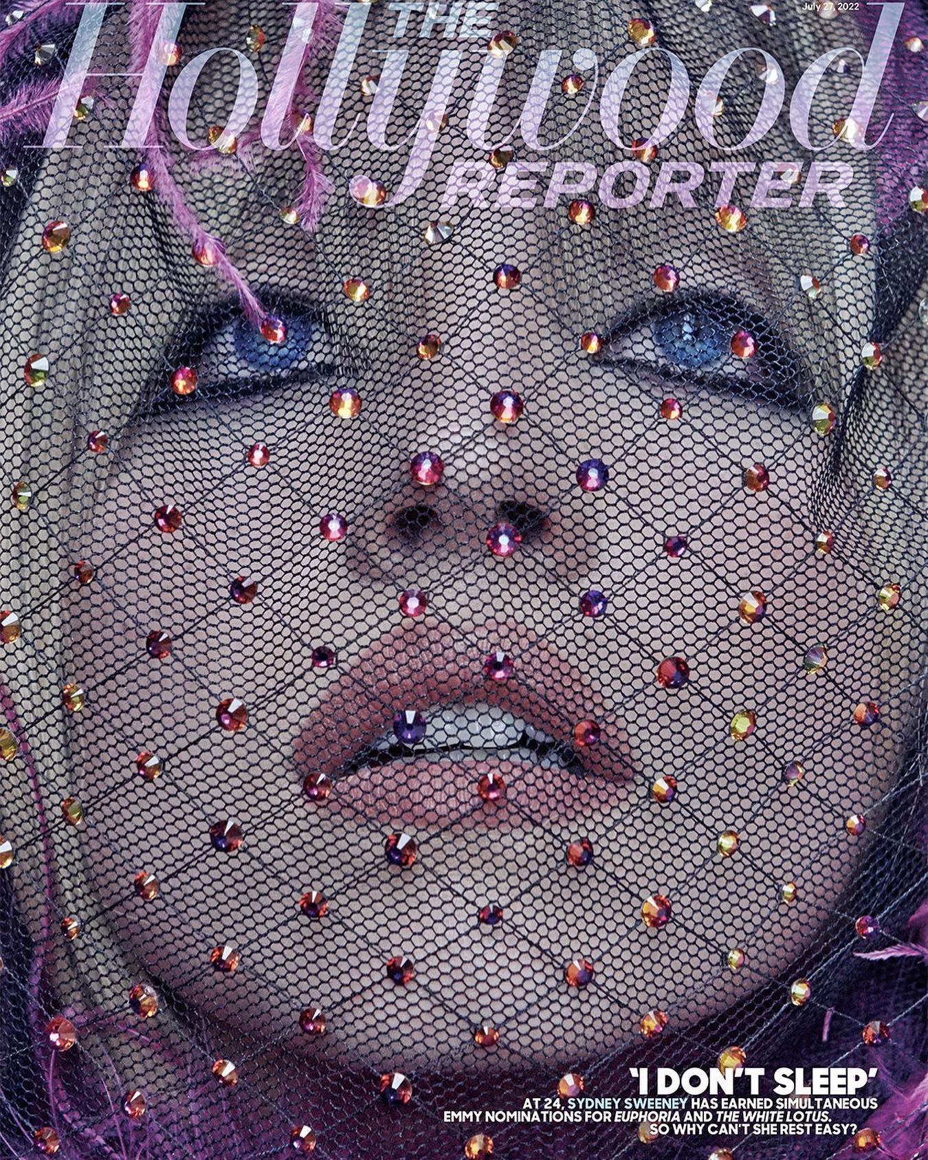 this is a magazine cover featuring sydney sweeney. she is wearing a black veil with small decorative beads.  the cover is for the hollywood reporter, and the headline reads "i don't sleep," referencing her simultaneous emmy nominations for euphoria and the white lotus.  the image is a closeup portrait, focusing on her face.