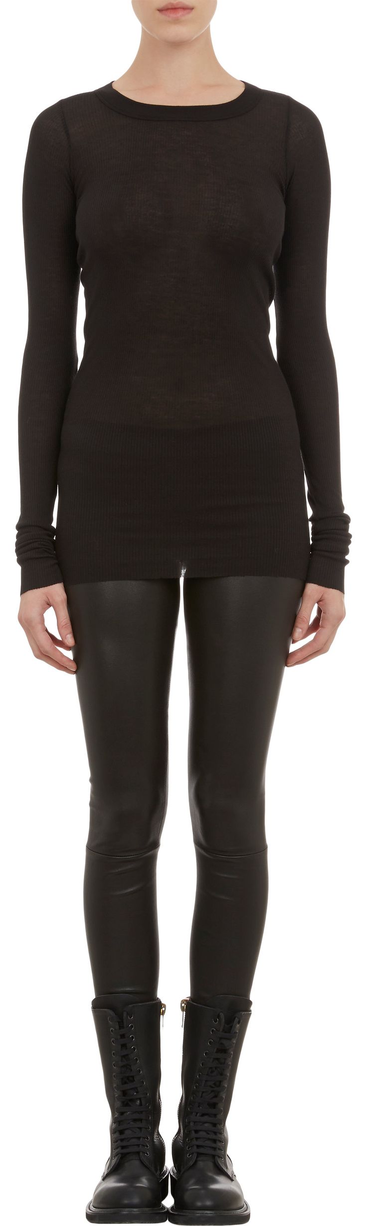 a slender woman is captured in a fulllength shot, posing against a clean, neutral background. she is dressed in a fitted, longsleeved black top paired with tight, black leather leggings. her footwear consists of black combat boots, completing the edgy ensemble.