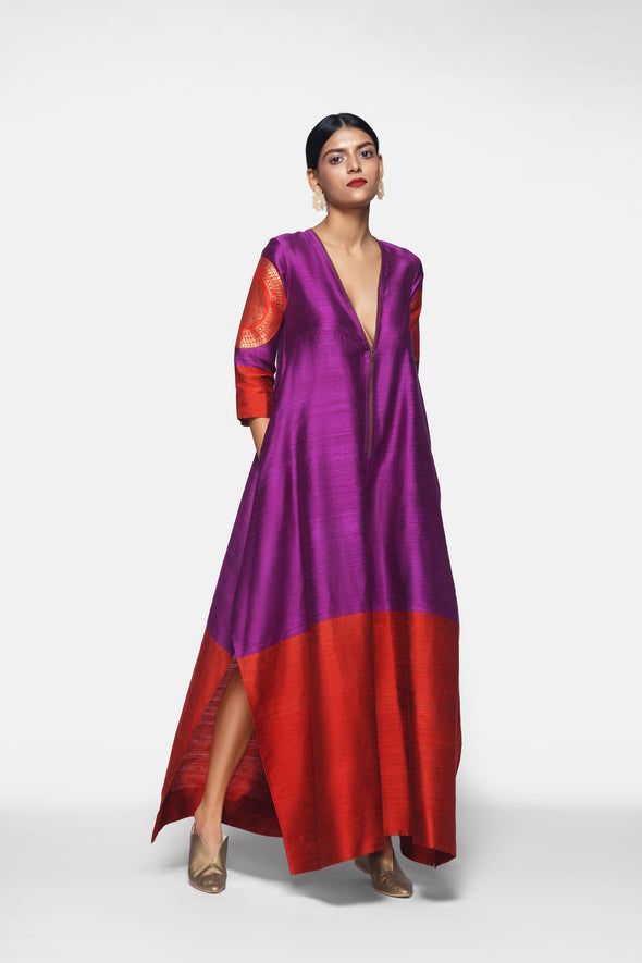 a woman is standing in a long, purple and red gown in front of a white background.