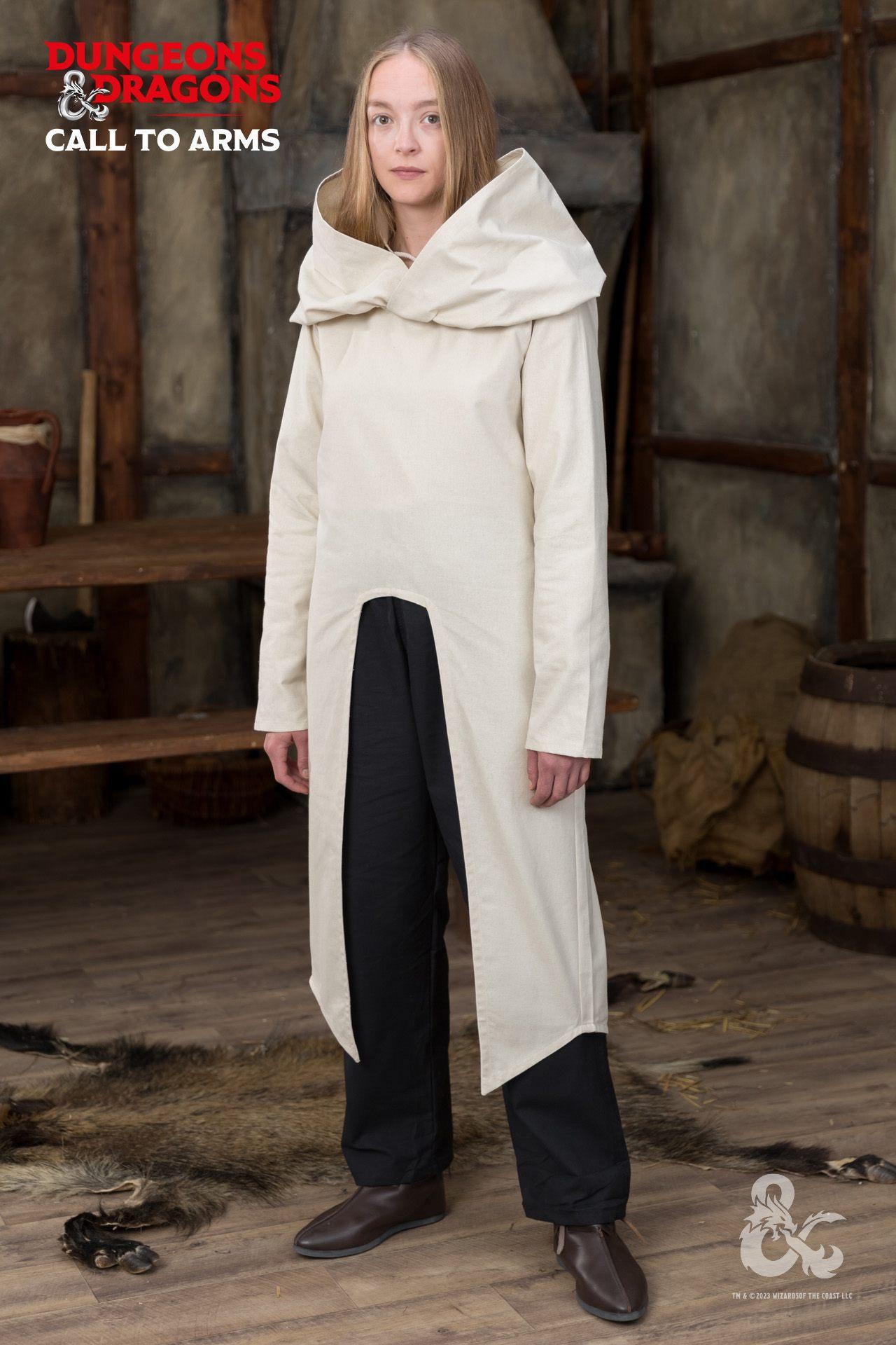 a woman stands in an interior setting wearing a creamcolored tunic with a large collar, black trousers, and brown leather shoes. the tunic has a slit up the front, revealing the trousers underneath. in the background are wooden walls, furniture, and a barrel. the "dungeons & dragons" logo is visible in the top left corner and the bottom right.