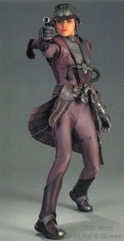 a woman in a star wars queen amidala cosplay costume. she is holding a blaster in her right hand.  she is wearing a purple outfit, black boots, and helmet.