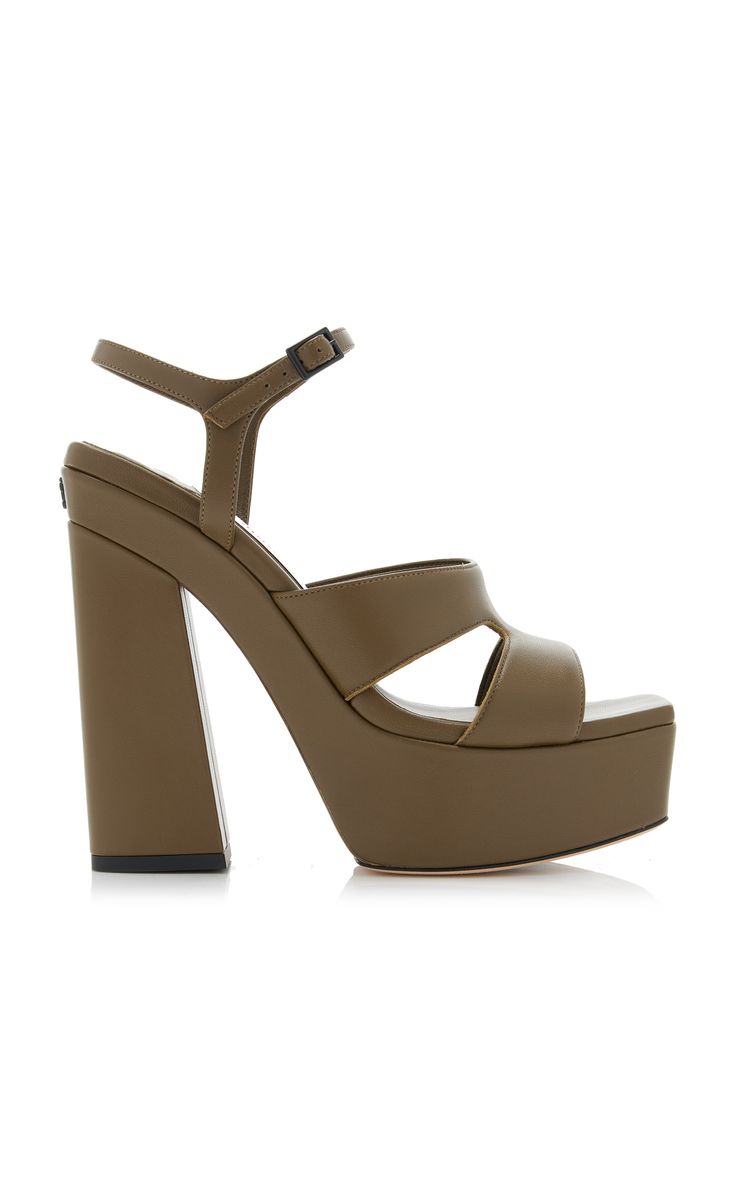 a studio shot of a pair of yves saint laurent olive green leather platform sandals. the sandals have a chunky heel, ankle strap and crisscross straps across the toes.  the shoes are shown on a white background.