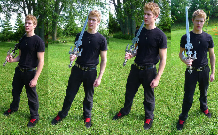 a collage of four images shows a young man, possibly a teenager, posing outdoors with a large fantasy sword. he is wearing a black tshirt and black pants with red sneakers. the background is a grassy parklike setting with trees in the background. the images are nearly identical except for slight variations in his pose and the angle of the sword. the overall impression is one of a fantasy or roleplaying theme.