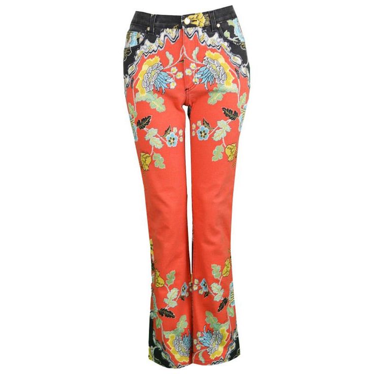 a pair of orange jeans with a colorful floral print, a black waistband, and a slightly flared leg.