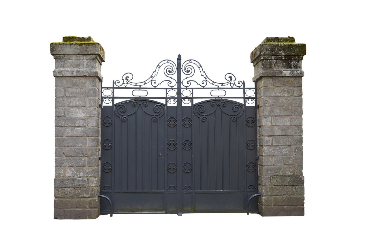 a wrought iron gate stands between two stone pillars. the gate is ornate with decorative swirls and scrollwork. the pillars are made of gray bricks and have moss growing on the tops. the background is black, isolating the gate and pillars.