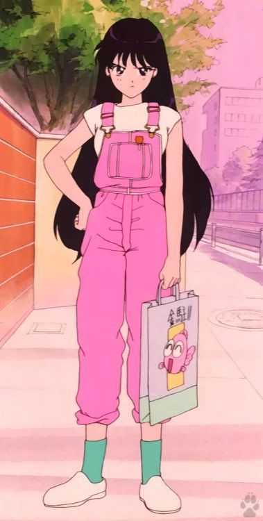 an animestyle girl stands on a sidewalk wearing pink overalls, a white tshirt, green socks, and white shoes. she is holding a shopping bag with a cartoon fish on it. the background shows a city street with buildings and trees.