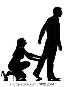 a silhouette of a man walking away from a woman who is kneeling and reaching out to him.