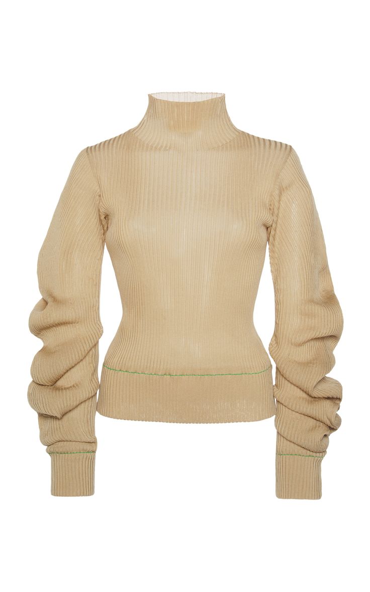 a beige ribbed turtleneck sweater with long sleeves and puff sleeves. the sweater is fitted and has a green seam along the bottom. the sleeves are gathered at the cuff, and there is a green seam along the cuffs as well. the sweater is made from a lightweight fabric and is perfect for layering in the colder months.