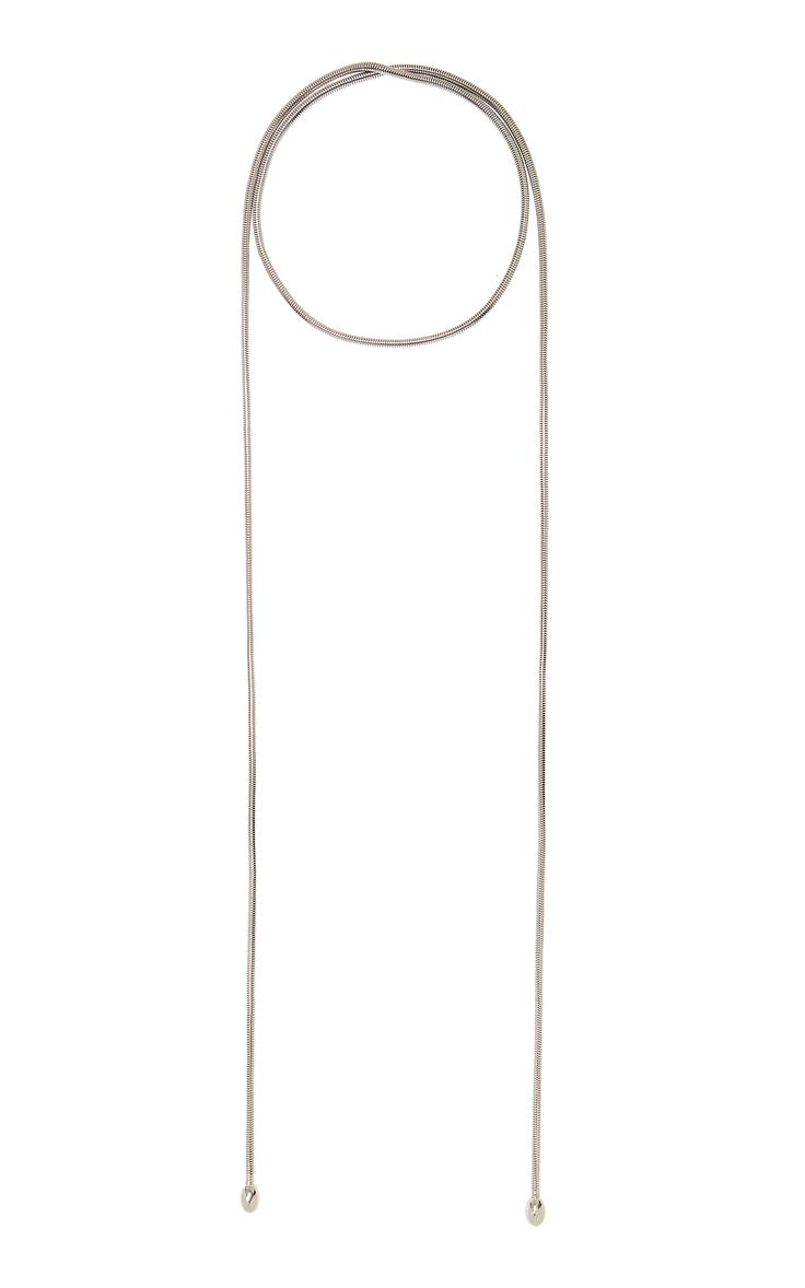 a simple yet elegant silver necklace. it features a long, thin chain with a delicate circle pendant at the top. the chain is made of two strands of silver wire, creating a minimalist and chic look. the necklace is perfect for adding a touch of sophistication to any outfit.