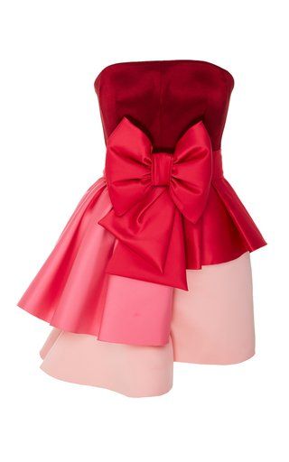 a strapless mini dress is shown. the top of the dress is a dark red color and is a straight across strapless cut. a large red bow is prominently displayed at the waist. the skirt has several layers in different shades of pink, with the top layer being the darkest shade and the bottom layer being the lightest. the background is plain white.