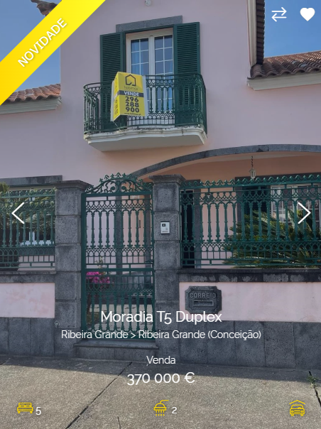this is a photo of a home for sale.  the sign reads "moradia t5 duplex".  the home has a pink facade.  the price of the home is listed at 370,000 euro. the house has a balcony with an ornate metal railing. there is a small mailbox with the word "correid" on it.  the house is surrounded by a green metal gate and fence.