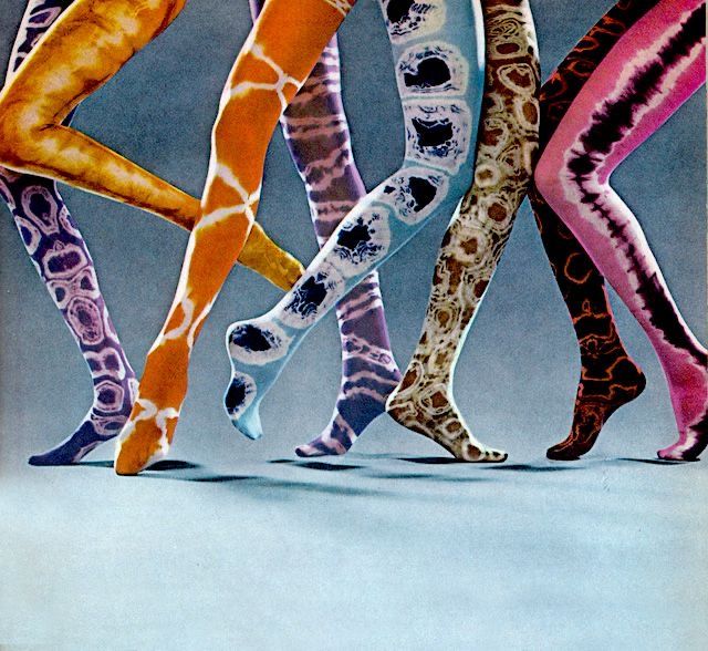 the image features a group of legs wearing patterned tights. there are five pairs of legs shown, each wearing tights with a different colorful pattern. the patterns include tiedye, abstract shapes, and a marblelike design. the legs are positioned as if they are walking or standing in a dynamic pose. the background is a plain bluegray color.