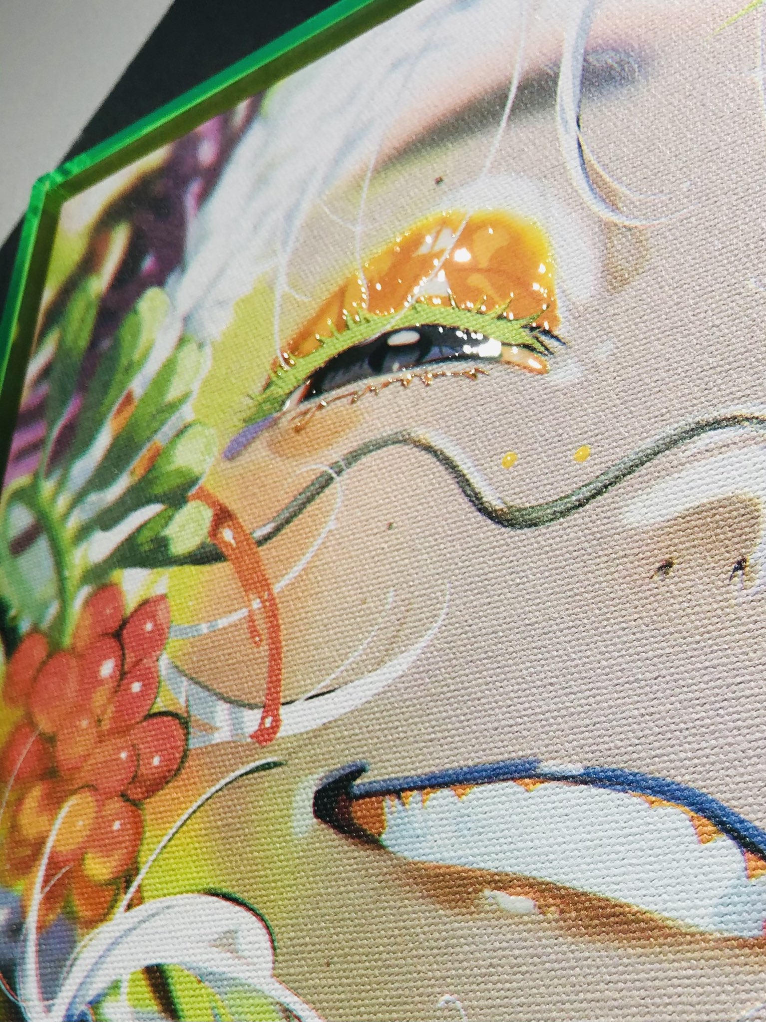 this is a closeup image of a colorful abstract painting of a woman's face. the painting is done in a variety of bright colors, with a focus on the eye and mouth. the painting is framed in a bright green frame.