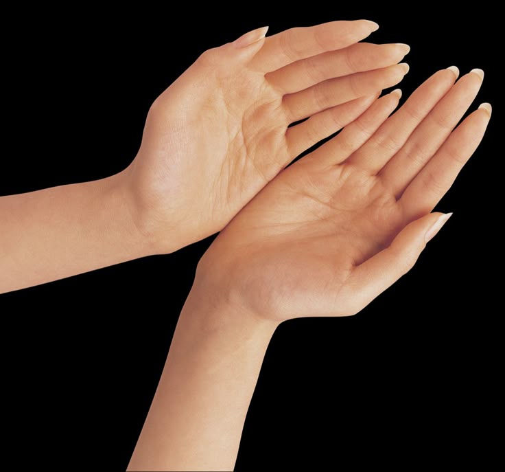 the image shows two fairskinned hands with neatly trimmed nails. the palms are facing upward, with the upper hand slightly cupped and above the lower hand. the background is solid black.