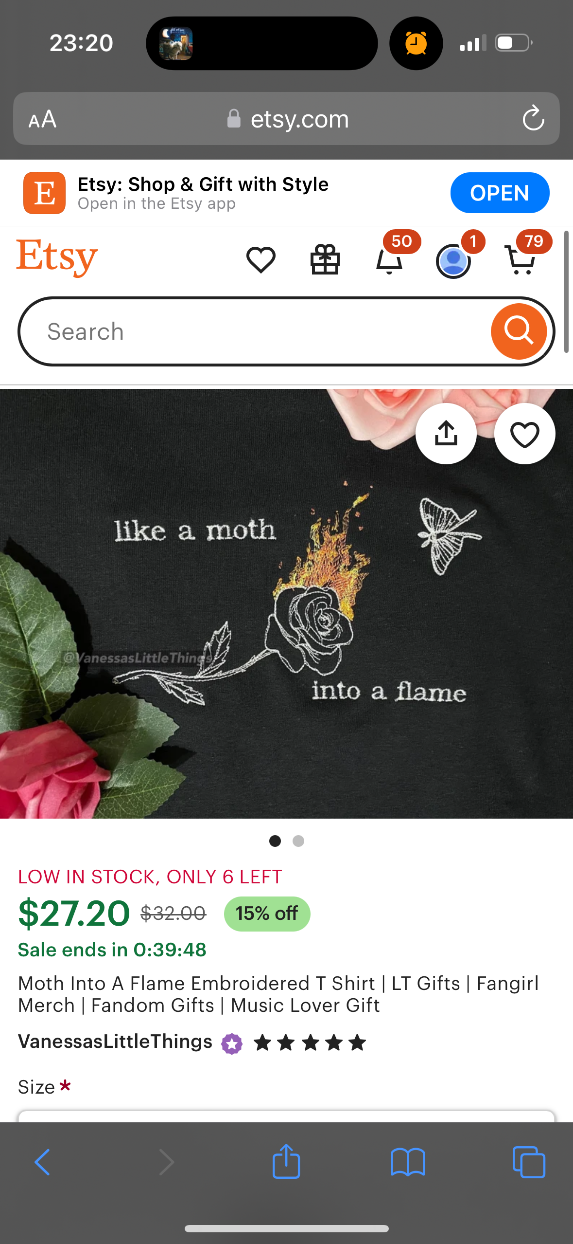 the image shows a listing from the etsy app. the listing is for a tshirt with the design of a rose with flames coming out of it and the text "like a moth into a flame" below it. the shirt is embroidered and is a popular gift for fans of music and fandom.