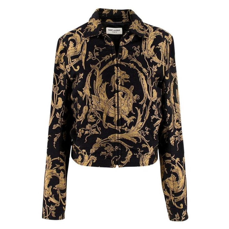 the image shows a cropped bomber jacket by saint laurent.  the jacket is black with a gold brocade pattern featuring intricate designs of dragons or griffins intertwined with floral elements.  the jacket has a zipup front and long sleeves. the overall style is luxurious and ornate.