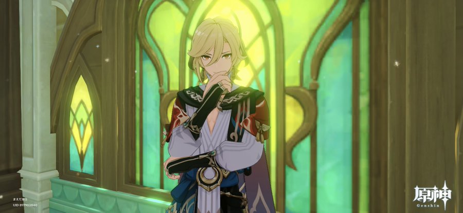 a digital image of alhaitham from genshin impact. he stands inside a building with decorative archways and stained glass windows in shades of green and yellow. he has blond hair and his hand is touching his chin as if in thought. the background is bright and blurred. the genshin impact logo appears at the bottom right of the image.