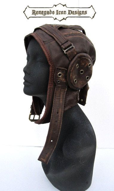 a closeup shot of a leather helmet made of brown leather with buckles and straps. the helmet is worn on a mannequin. it appears to be a vintage helmet that might have been used for motorcycling, piloting, or as a costume prop.