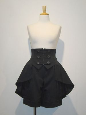 a black dress with a peplum and highwaisted shorts is shown on a mannequin. the dress has militaryinspired buttons down the front. the image is taken indoors with bright lighting.