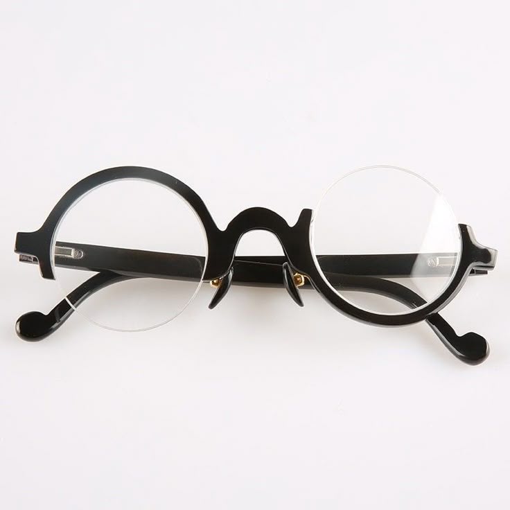 the image shows a pair of round rimless glasses with a black frame. the glasses are positioned on a white surface and are oriented horizontally.