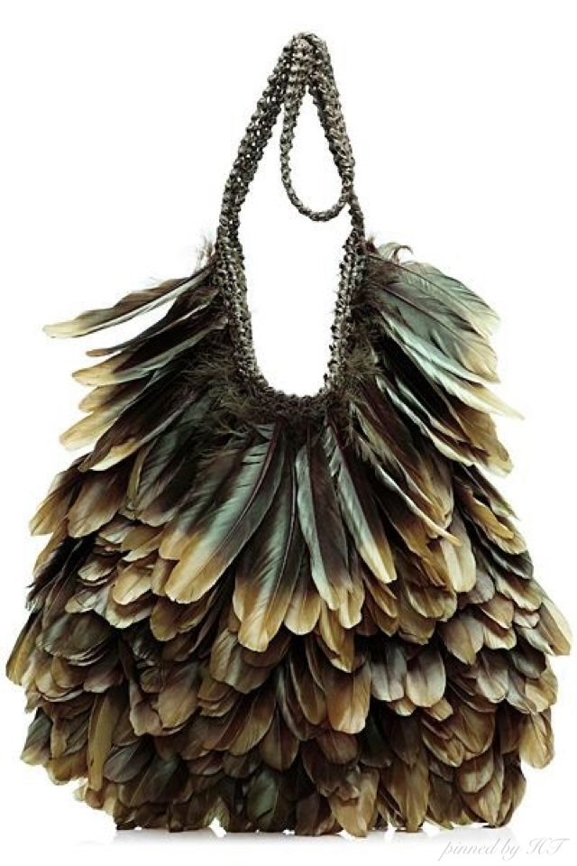 the image shows a handbag completely covered in brown and green iridescent feathers. the handles of the bag are also feathered, with a looped section in the center. the feathers are densely layered, creating a textured and voluminous look. the handbag appears to be a highfashion accessory.