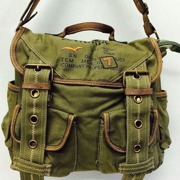 a green canvas shoulder bag with brown straps, buckles and pockets. the bag has a vintage, military style and is perfect for travel or casual wear. the bag has a zipper closure and is made of durable canvas.
