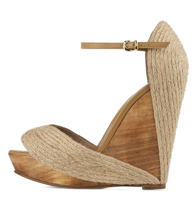a pair of women's beige espadrille wedge sandals are displayed on a white background. the sandals have a jute upper, a wooden wedge heel and an ankle strap. the sandals are opentoed and appear to be casual summer footwear.