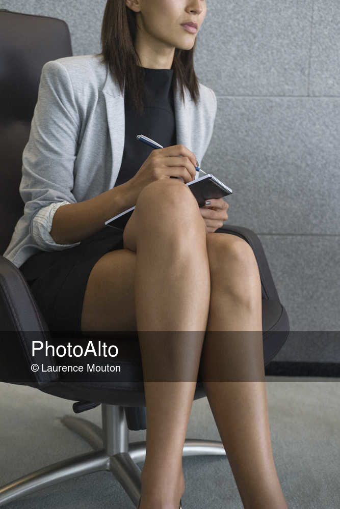 Businesswoman sitting with legs crossed, cropped - Photoalto.