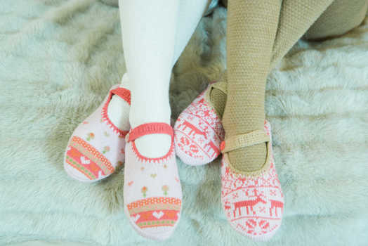 Two teen girls sitting by fireplace, wearing tights and slippers