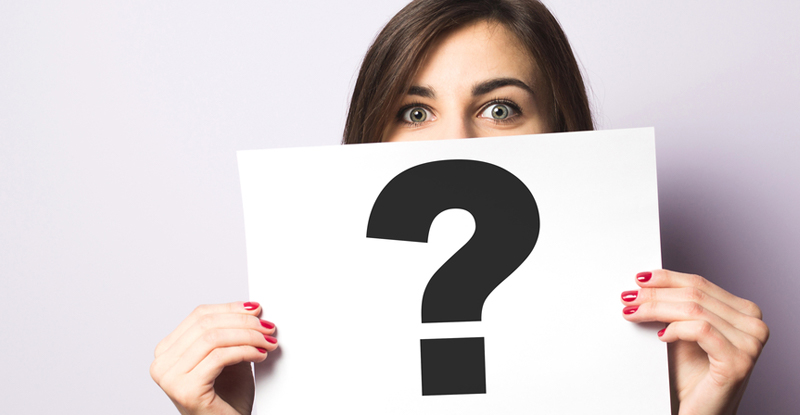 Woman holding sign with question mark for FAQs about veins