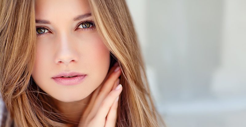 Close-up of pretty woman with straight brown hair and wrinkle-free face