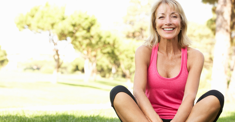 Middle-aged lady doing yoga outdoors