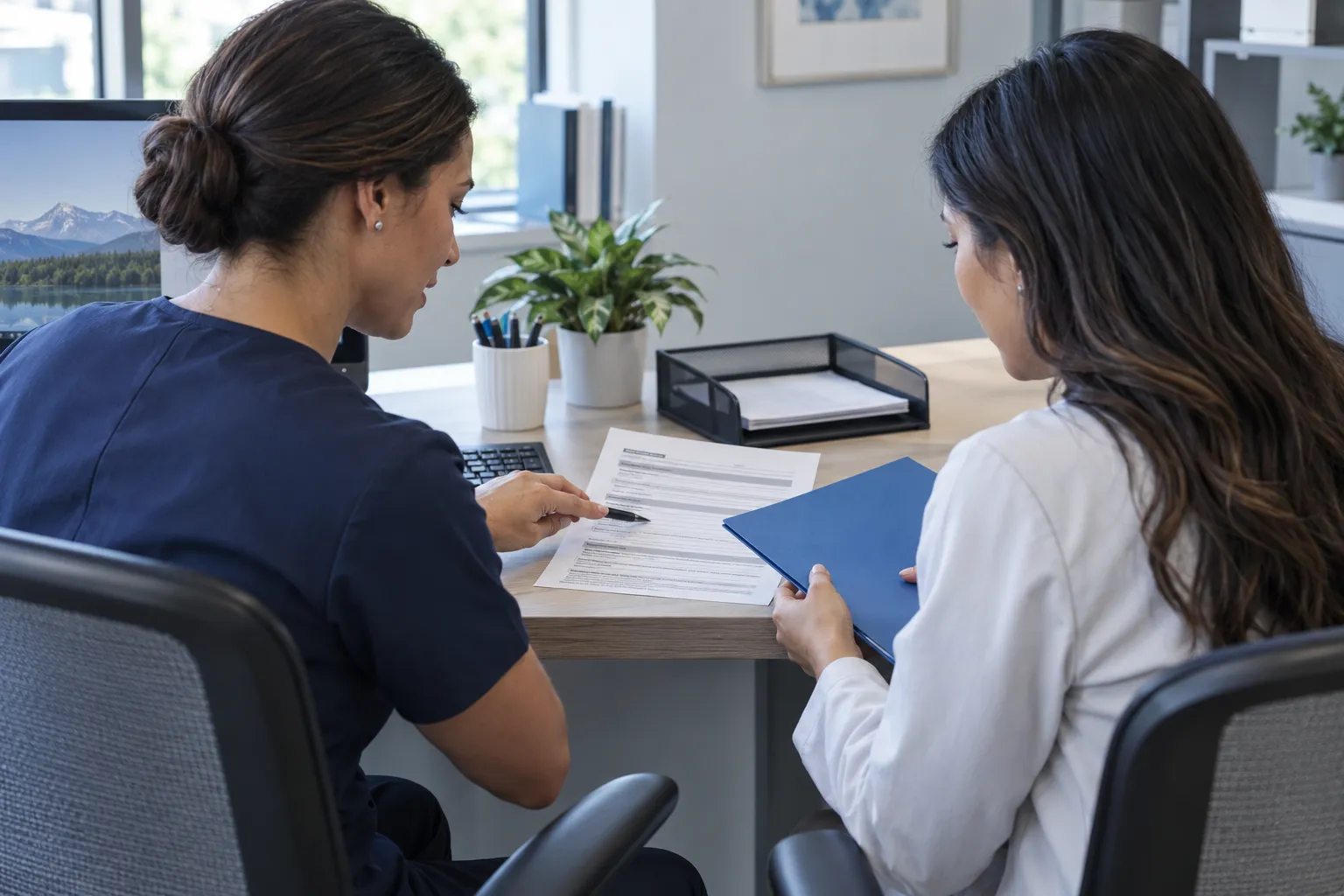 Two healthcare office professionals review a readiness document while handing off a blue folder.