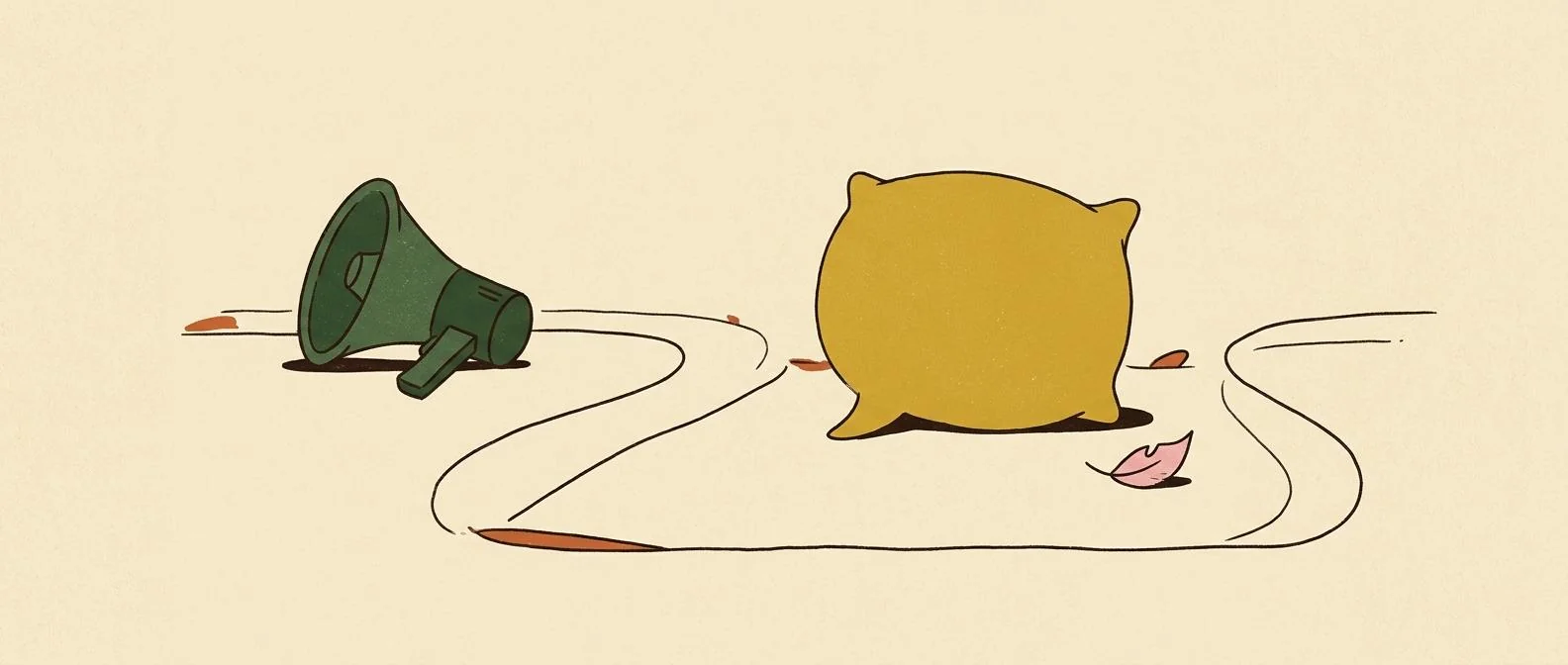 A megaphone set down beside a soft speech-bubble cushion and leaf.