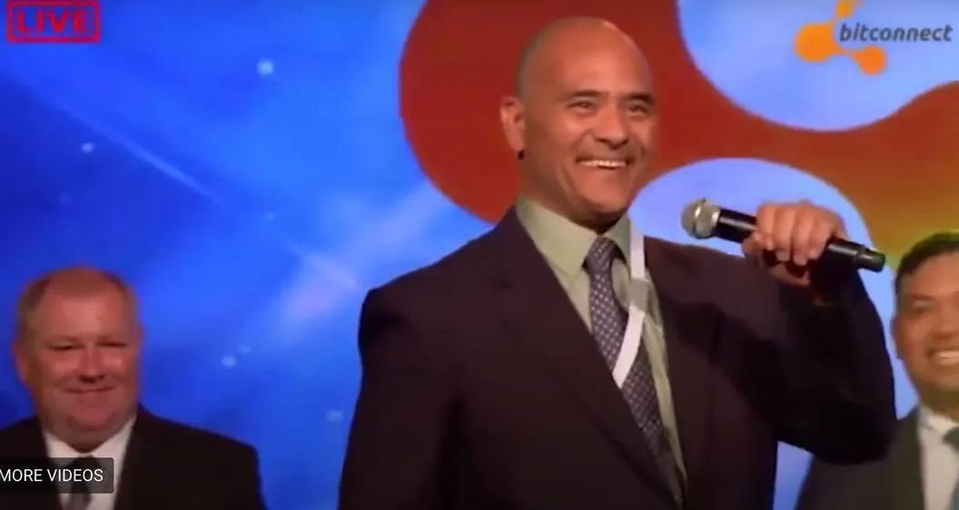 Carlos Matos, a well-known promoter of Bitconnect, is seen energetically speaking into a microphone on stage, embodying the high-spirited and persuasive marketing tactics that contributed to the infamous cryptocurrency scheme’s widespread impact. Source: The Lesson of Bitconnect: Promoters Can Be Liable, Coindesk.