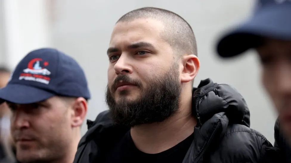 Faruk Fatih Ozer, the CEO of the now-defunct Thodex exchange, is seen in custody. He fled Turkey after the collapse of Thodex, which defrauded investors of millions of dollars. He and his two siblings have each been sentenced to 11,196 years in prison for their roles in the scam. Source: Thodex cryptocurrency boss jailed for 11,196 years in Turkey for fraud, BBC.