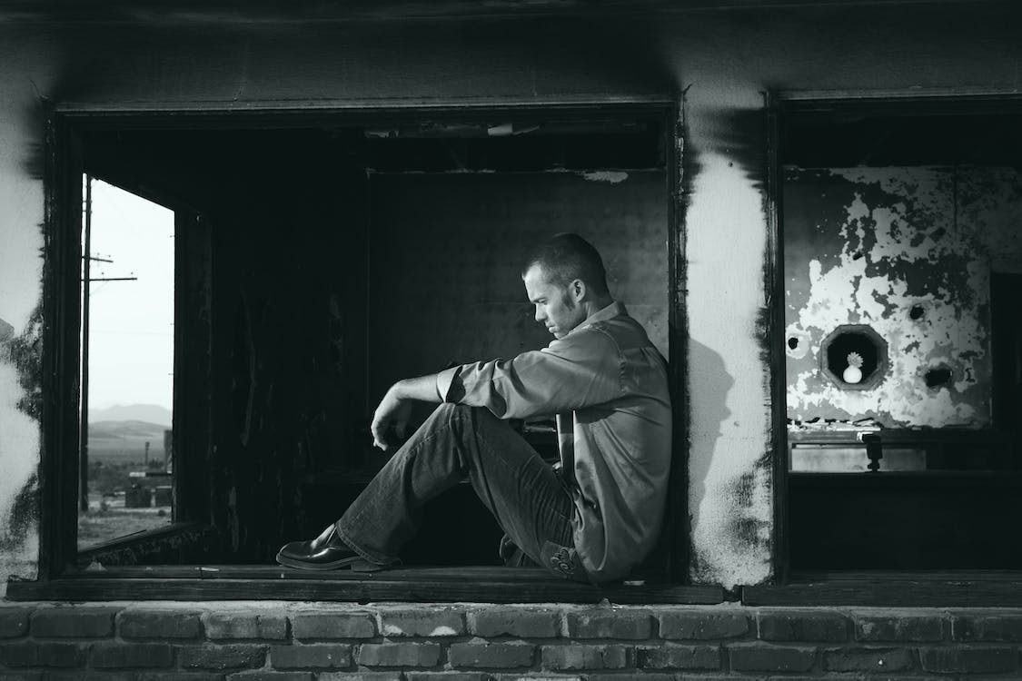 Free Grayscale Photo of Man Sitting Stock Photo