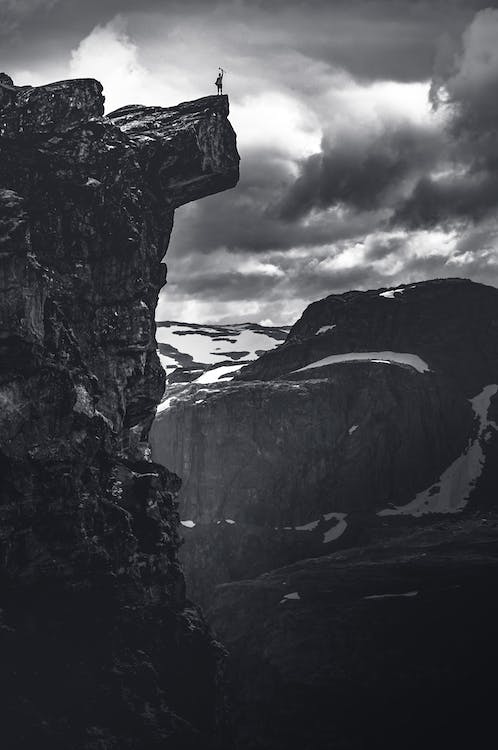 Free Grayscale Photo of Rocky Mountain Under Cloudy Sky Stock Photo